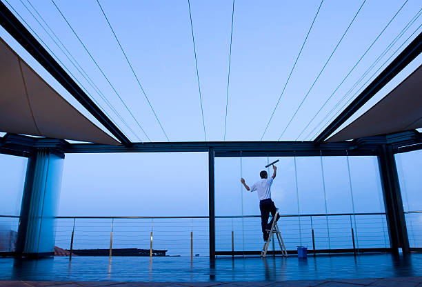 Cleaner working on a building's exterior in the early morning, showcasing our commercial cleaning services.