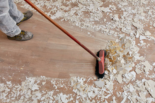 Builder using high-pressure cleaning to tidy up the floor after renovations.