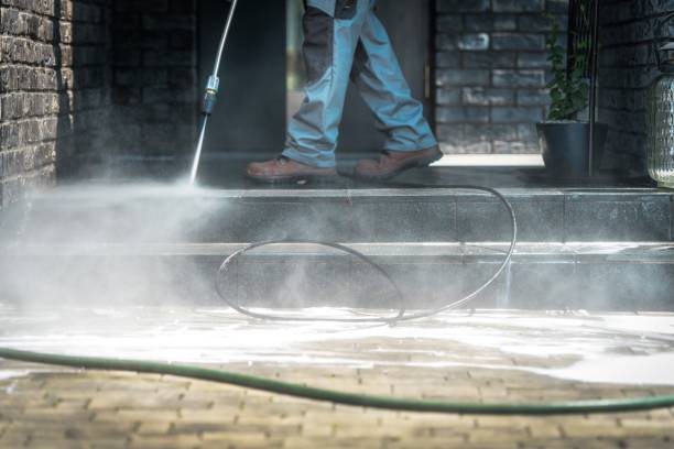 Pressure Washer Cleaning Time. Men Cleaning Outside House Stairs with Power High Pressured Cleaner.