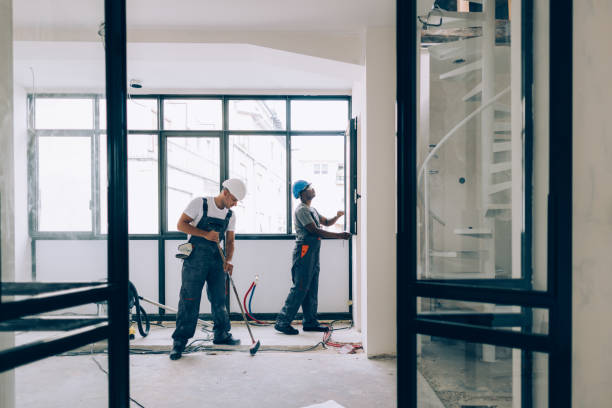 Two professionals collaborating on a house cleaning project in an unfinished space.