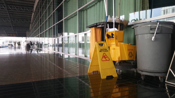 The warning signs cleaning and caution wet floor in the building and janitorial car parked in back to remind people to walk safely.