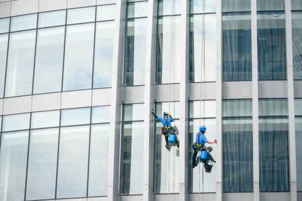 Staff members washing windows on a high-rise structure.