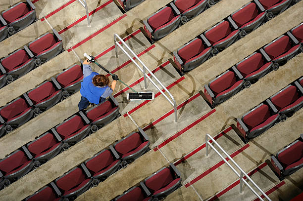 A young man wash a stadium, perform cleaning services.