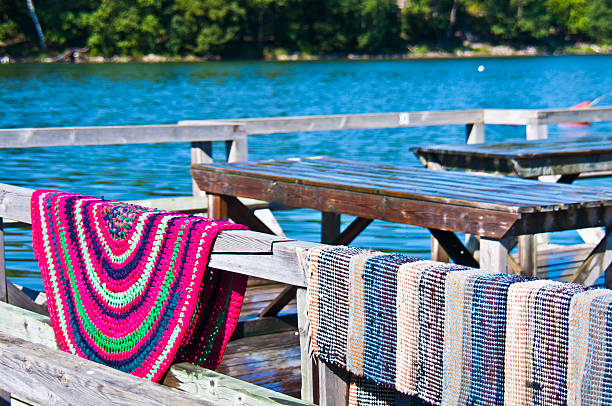 Seaside carpet washing station with a freshly cleaned carpet hanging to dry near the water.