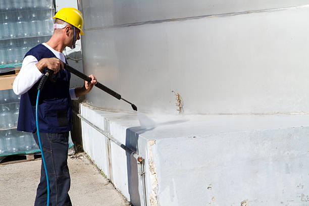 Electrician and general worker washing the industrial site in a wine company.