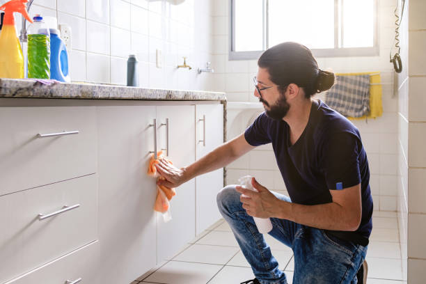 Portrait of latin man cleaning empty apartment.