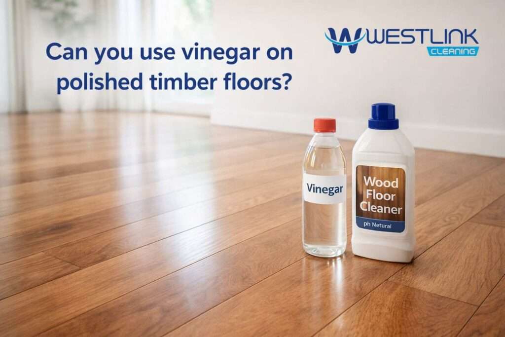 Vinegar bottle and wood floor cleaner beside a polished timber floor in a modern home