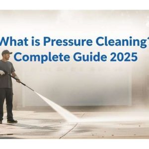 Technician pressure washing a residential driveway using a professional high-pressure machine.